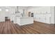 Modern kitchen with white cabinets, stainless steel appliances, a large island, and wood floors at 4949 Hickory Oaks St, Castle Rock, CO 80104