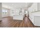 Spacious open kitchen features white cabinets, stainless steel appliances, a large island, and wood floors at 4949 Hickory Oaks St, Castle Rock, CO 80104