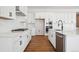 Bright kitchen with white cabinets, stainless steel appliances, tile backsplash, and wood floors at 4949 Hickory Oaks St, Castle Rock, CO 80104