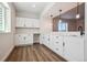 Charming kitchenette featuring white cabinets, modern hardware, wood floors, and pendant lighting at 4949 Hickory Oaks St, Castle Rock, CO 80104
