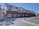 Spacious townhome exterior showing brick and gray siding, individual garages, and ample parking at 3030 W Prentice Ave # G, Littleton, CO 80123