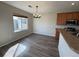 Bright dining area featuring wood floors, a modern chandelier, and a large window at 13013 Grant Cir # C, Thornton, CO 80241