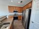 Well-equipped kitchen boasting stainless steel appliances, wooden cabinets, and sleek countertops at 13013 Grant Cir # C, Thornton, CO 80241