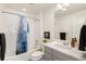 Modern bathroom featuring a shower-tub combo, gray vanity with white countertop, and stylish fixtures at 5668 Galena St, Denver, CO 80238