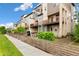 Modern townhome exterior with private balconies, a green door, and well-maintained landscaping at 5668 Galena St, Denver, CO 80238