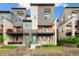 Modern townhome with a well-kept lawn, a wood fence, and a lovely entrance and porch with red railings at 5668 Galena St, Denver, CO 80238