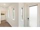 Bright hallway with natural light from multiple windows and a view into the laundry room at 5668 Galena St, Denver, CO 80238