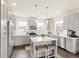 The well-lit kitchen features stainless appliances, an island with barstools, grey cabinets, and white countertops at 5668 Galena St, Denver, CO 80238