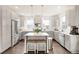 Modern kitchen features stainless steel appliances, an island with barstools, and light grey cabinets at 5668 Galena St, Denver, CO 80238