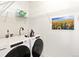 A well-equipped laundry room with a Whirlpool washer and dryer, wire shelving, and bright sunflower art at 5668 Galena St, Denver, CO 80238