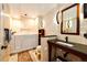 Accessible bathroom featuring a walk-in tub, stone-tiled walls, and modern vanity at 11437 Tomichi Dr, Franktown, CO 80116