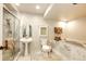Bright, all-white tiled bathroom with pedestal sink, soaking tub and glass enclosed shower at 11437 Tomichi Dr, Franktown, CO 80116