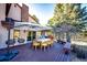 Outdoor deck with patio dining set and umbrella overlooking private treed backyard at 11437 Tomichi Dr, Franktown, CO 80116