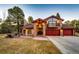 Charming brick home featuring a three-car garage, balcony, and a welcoming front yard with a fire pit at 11437 Tomichi Dr, Franktown, CO 80116