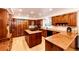 Gourmet kitchen with custom wood cabinetry, granite countertops, and a central island cooktop for culinary enthusiasts at 11437 Tomichi Dr, Franktown, CO 80116