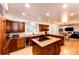 Spacious kitchen featuring granite countertops, wood cabinetry, and a central island cooktop at 11437 Tomichi Dr, Franktown, CO 80116