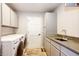 Functional laundry room with modern appliances, storage cabinets, and a sink at 11437 Tomichi Dr, Franktown, CO 80116
