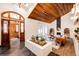 Spacious living room with wood ceiling, white brick accents, fireplace, and modern furnishings under a chandelier at 11437 Tomichi Dr, Franktown, CO 80116