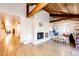Spacious living area features a brick fireplace, wood beam ceiling, and play area at 11437 Tomichi Dr, Franktown, CO 80116