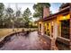 Backyard patio with a fire pit, seating area, and access to the home's sunroom through elegant glass doors at 11437 Tomichi Dr, Franktown, CO 80116