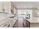 Bright kitchen with white cabinets, stainless steel appliances, and hardwood floors at 25284 E Warren Pl, Aurora, CO 80018