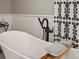 Bright bathroom featuring a modern soaking tub, sleek fixtures, and stylish black and white patterned shower curtain at 280 E 11Th Ave, Broomfield, CO 80020