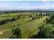 Scenic view of the golf course with lush green fairways, trees, and distant mountain views under a bright sky at 280 E 11Th Ave, Broomfield, CO 80020