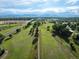 Expansive view of a lush green golf course under a bright, partly cloudy sky with distant mountains at 280 E 11Th Ave, Broomfield, CO 80020