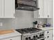Close-up of a kitchen with stainless steel appliances, granite countertops, and a stylish backsplash and range hood at 280 E 11Th Ave, Broomfield, CO 80020