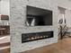 Stylish living room featuring a modern linear fireplace with stone surround and a large, mounted flatscreen TV at 280 E 11Th Ave, Broomfield, CO 80020