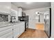 Well-lit kitchen featuring white cabinets and stainless steel appliances at 6670 Hooker St, Denver, CO 80221