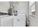 Well-lit laundry area featuring a white washer and dryer set, water heater, and wire shelving above at 6670 Hooker St, Denver, CO 80221