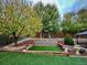Landscaped backyard featuring a terraced retaining wall and lush green lawn for outdoor enjoyment at 9011 Sandpiper Dr, Longmont, CO 80504