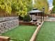 Inviting backyard setup with a gazebo, putting green, and retaining wall, perfect for entertaining at 9011 Sandpiper Dr, Longmont, CO 80504