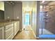Bathroom featuring glass shower with a bench, double vanity and tile flooring at 9011 Sandpiper Dr, Longmont, CO 80504