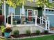 Welcoming front porch with a decorative wreath, manicured landscaping, and a cozy seating area at 9011 Sandpiper Dr, Longmont, CO 80504