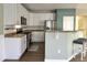 Bright kitchen features white cabinets, stainless steel appliances and bar seating at 9011 Sandpiper Dr, Longmont, CO 80504