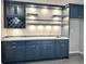 Wet bar with sleek navy cabinets, tile backsplash, wine storage, and countertop space at 9011 Sandpiper Dr, Longmont, CO 80504