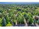 Aerial view showcasing the house nestled in a treelined neighborhood with mountain views at 6325 E Tufts Ave, Cherry Hills Village, CO 80111