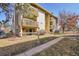 Multi-story condo building with tan siding, brown trim, and private balconies in a landscaped yard at 4064 S Atchison Way # 204, Aurora, CO 80014