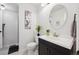 Bright bathroom features a black vanity, oval mirror, and a flower accent at 8010 Holland Ct # D, Arvada, CO 80005