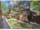 Exterior view of home showing mature trees, private patio area, and wood siding at 8010 Holland Ct # D, Arvada, CO 80005