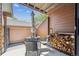Covered outdoor patio with table, chairs, firewood, and wood-paneled privacy fencing at 8010 Holland Ct # D, Arvada, CO 80005