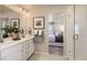 Bathroom with double vanity, shower, and bedroom view at 1465 Bloom St, Brighton, CO 80601