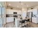 Modern kitchen with white cabinets, granite countertops, and island with seating at 1465 Bloom St, Brighton, CO 80601