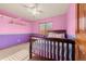 Bright bedroom with pink walls, wood bed frame, and ceiling fan at 7562 E 130Th Cir, Thornton, CO 80602