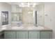 Bathroom featuring dual sinks, a large mirror, and decorative lighting at 7944 E Lowry Blvd, Denver, CO 80230