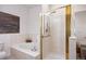 Bathroom with a luxurious tub, separate shower with gold trim, and tiled walls at 7944 E Lowry Blvd, Denver, CO 80230