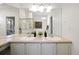 Bathroom with a double sink vanity, a large mirror, and ample lighting at 7944 E Lowry Blvd, Denver, CO 80230