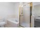 Tiled bathroom featuring a shower with brass trim, tub, and toilet at 7944 E Lowry Blvd, Denver, CO 80230